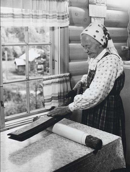 Norwegian woman using a mangle board